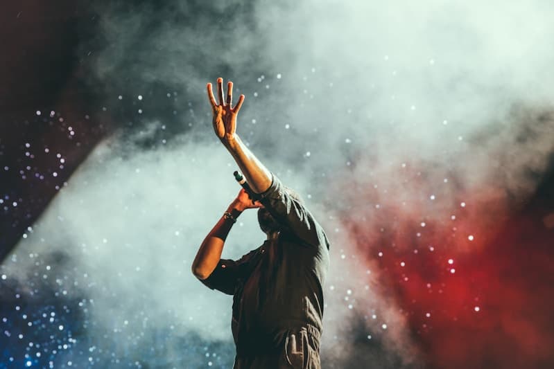 Performer on stage under stage lights and smoke at a live music gig